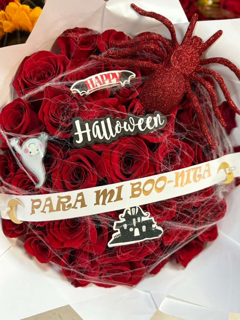 Red rose bouquet with Halloween decorations and a glittery spider