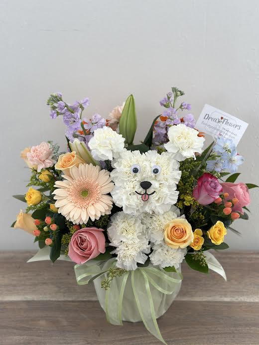Flower arrangement shaped like a white teddy bear with roses and daisies