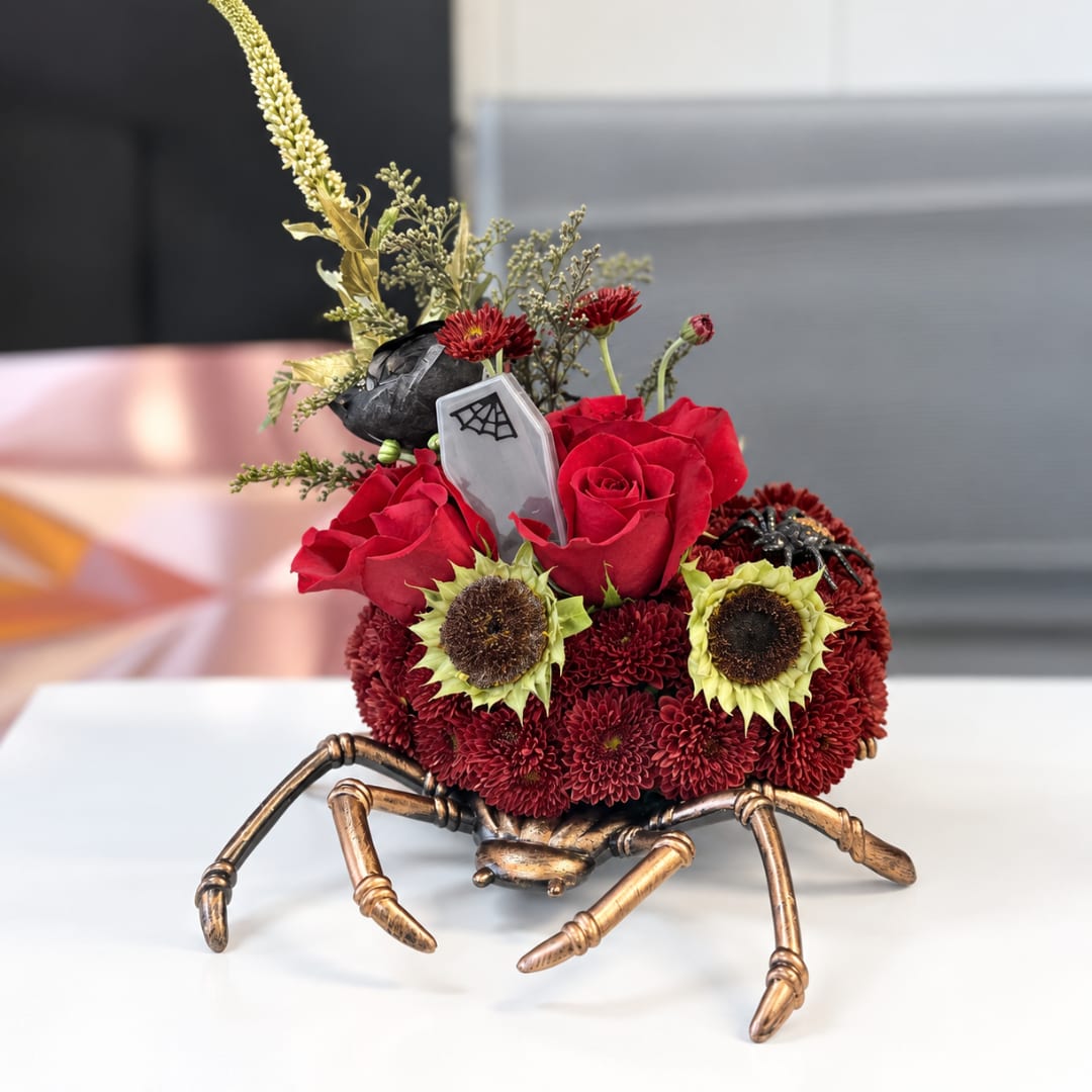 Red roses and chrysanthemums arranged in a spider-shaped container