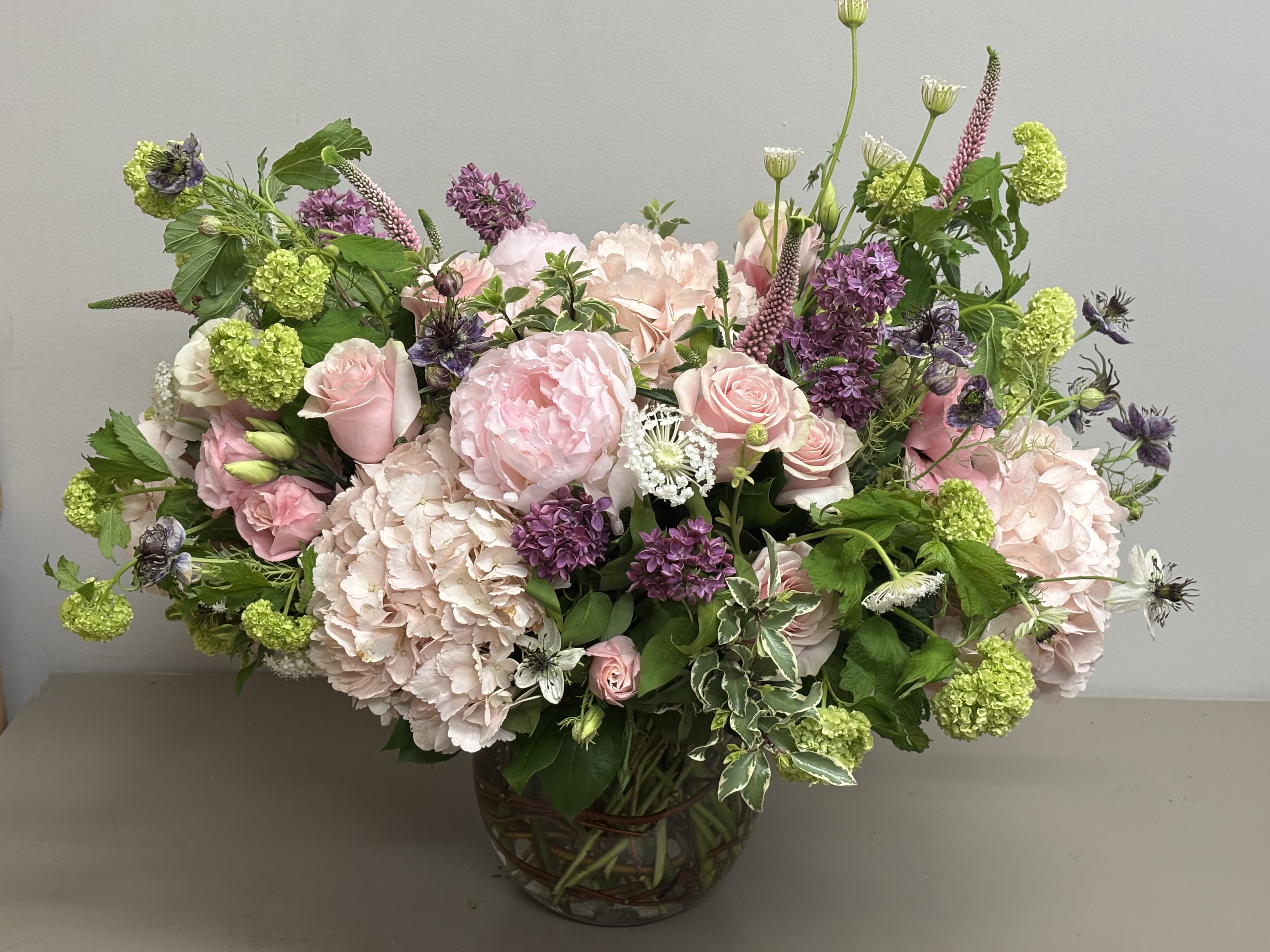 Bellissima - Beautiful combination of Hydrangeas, Roses, Peonies &amp; other seasonal flowers in a glass vase. 