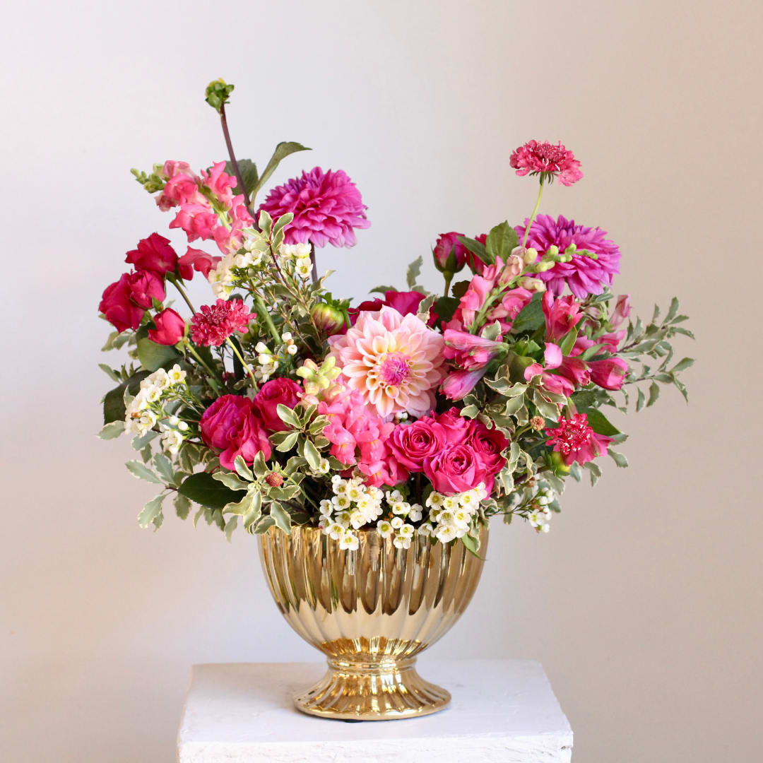 Pink and white mixed flower arrangement in a gold vase