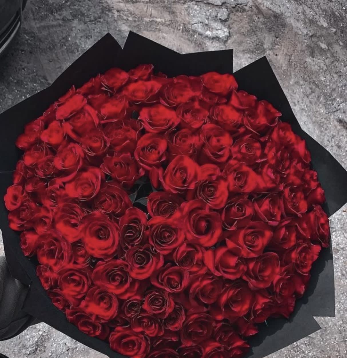 Large bouquet of red roses wrapped in black paper