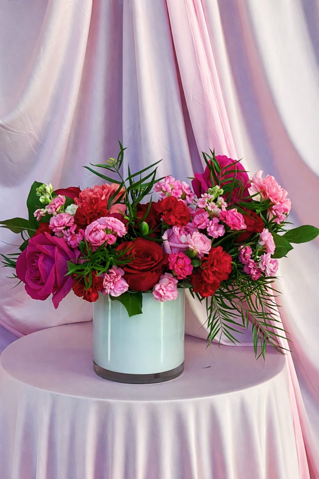 Pink and red flower arrangement in a white vase