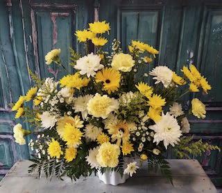 Yellow and white mixed flower arrangement in a white vase