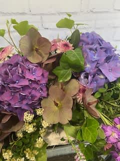 Bouquet of purple and tan hydrangeas with green foliage
