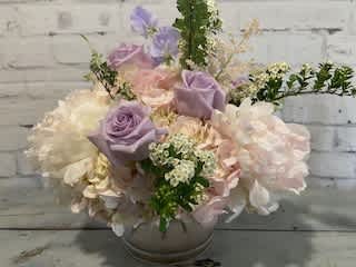 Pastel bouquet of roses and hydrangeas in a round vase