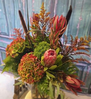 Fall Glory - All the seasonal feels with this gloripous creation brimming with hydrangea and beautiful seasonal greens in muted shades of orange, coral and green.  