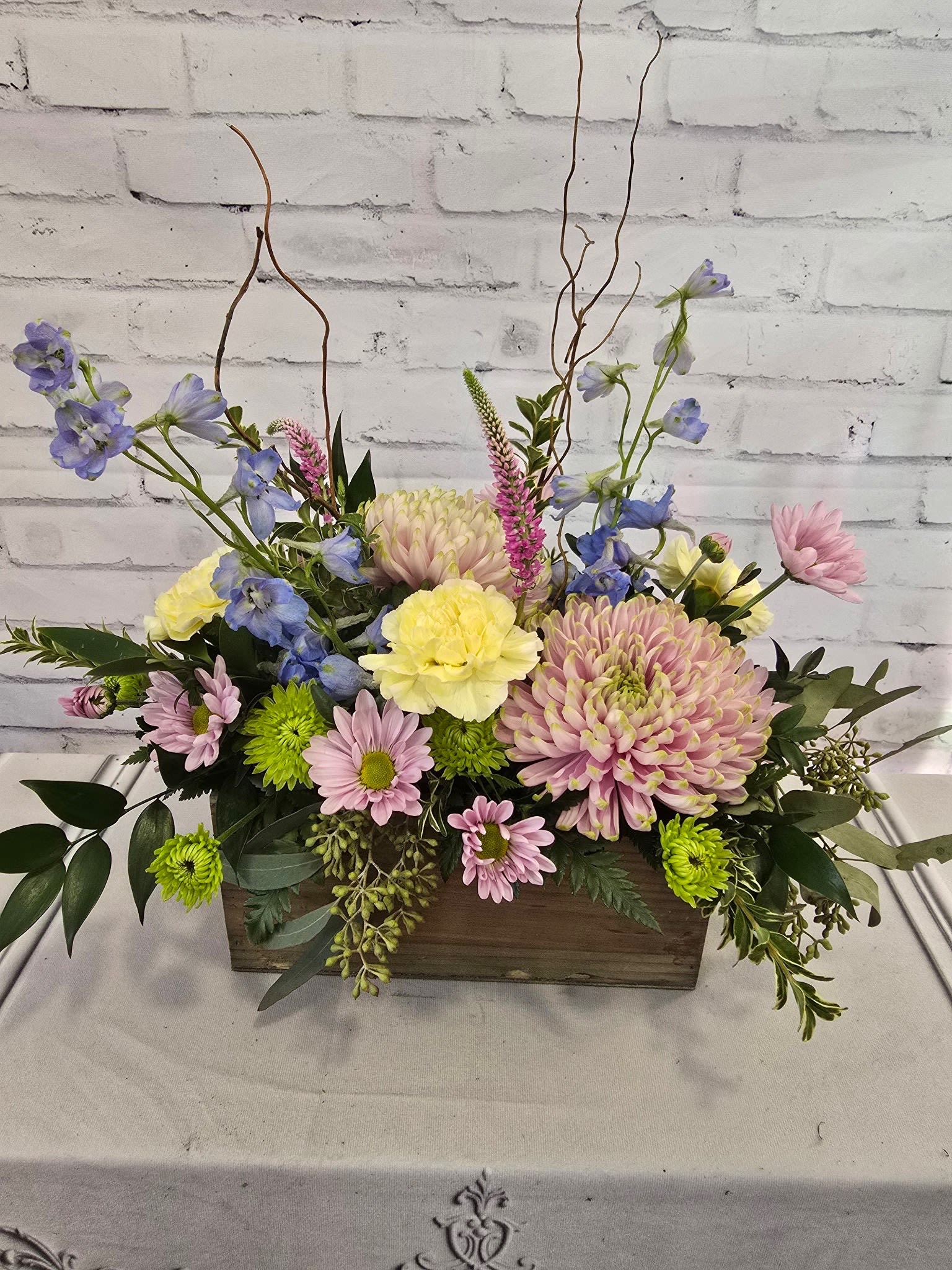 Mixed pastel flower arrangement in a wooden box