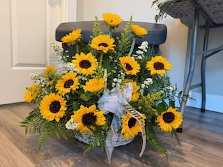 Basket of Sunshine - A dense cluster of bright yellow sunflowers-their dark centers drawing the eye-creates an immediate sunny focal point in this flower arrangement. As a wedding table accent or a thoughtful sympathy and funeral tribute, this basket arrangement carries a warm, uplifting presence that reads both celebratory and comforting; the person you're thinking of will feel seen and gently supported.
