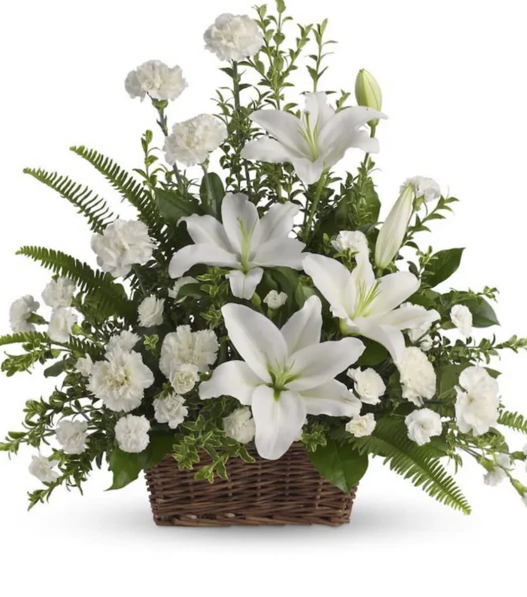 White lilies and carnations arranged in a wicker basket