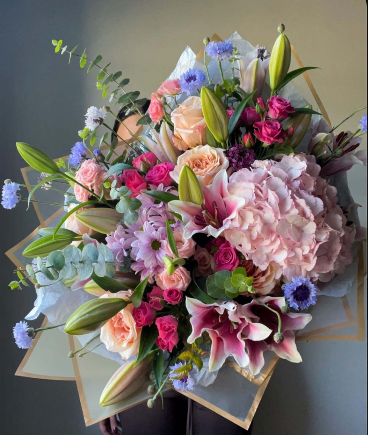 Large bouquet of pink lilies, roses, hydrangea, and blue accent flowers