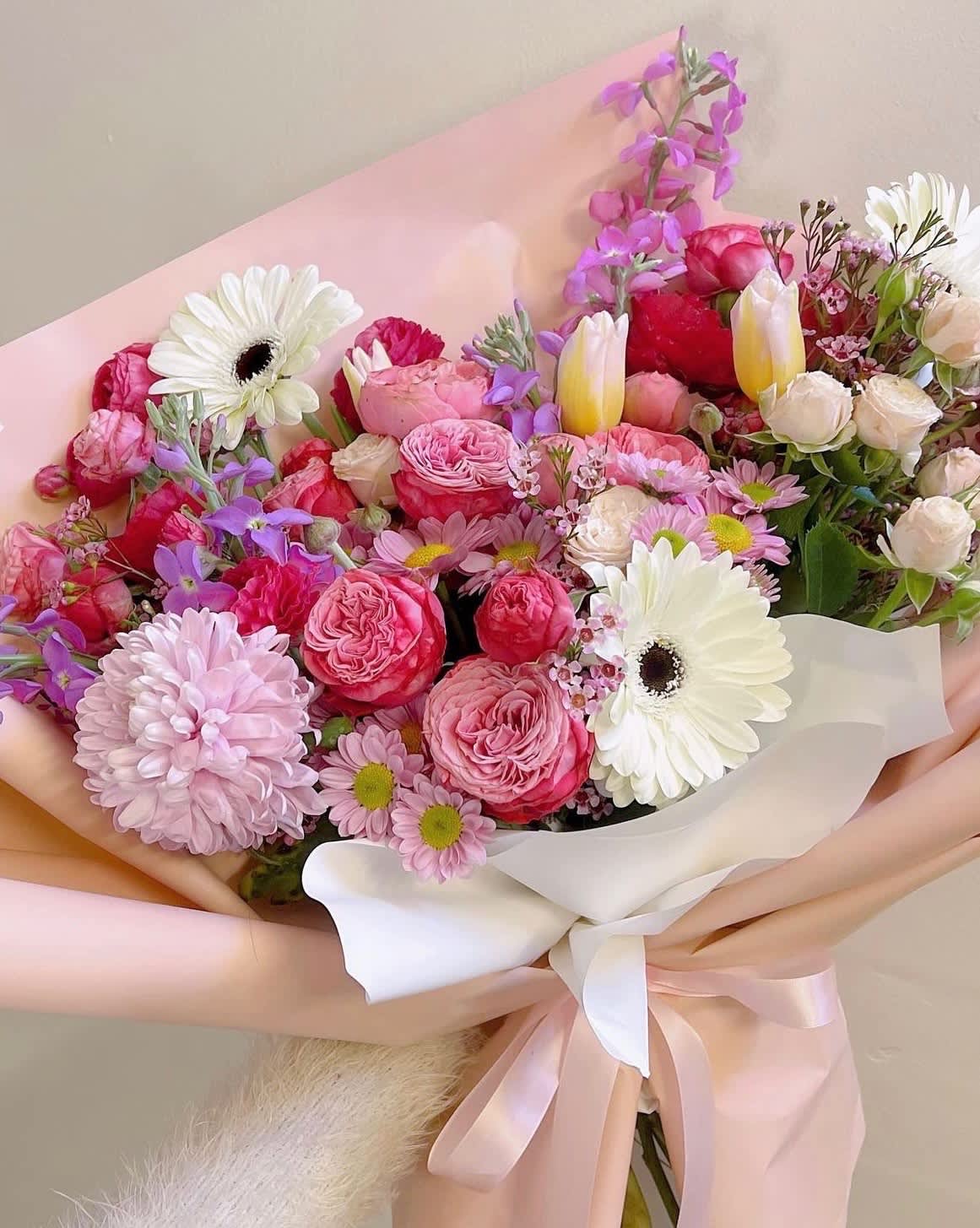 Pink and white mixed bouquet with gerbera daisies and roses wrapped in pastel paper