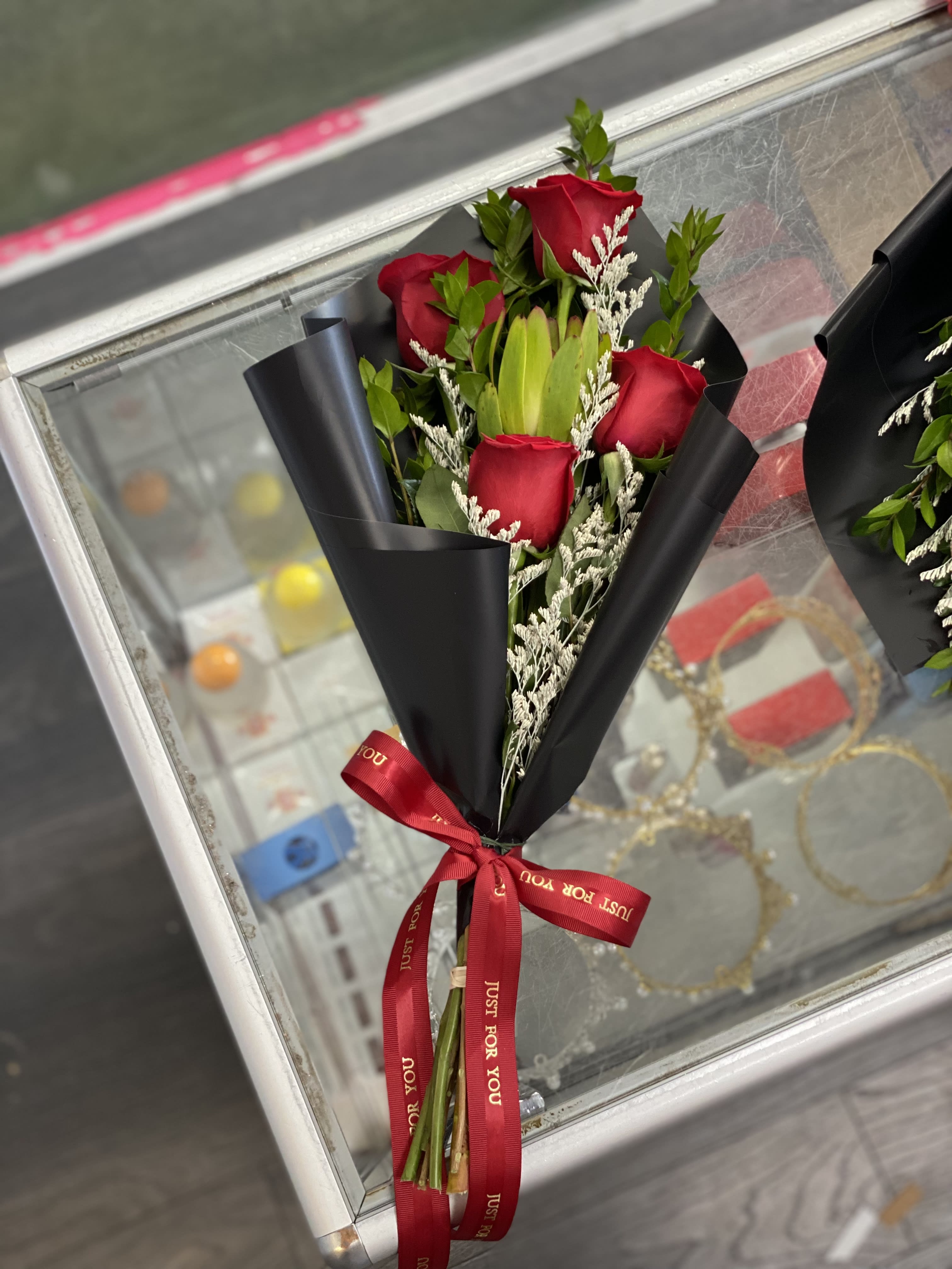 Bouquet of red roses wrapped in black paper with a red ribbon
