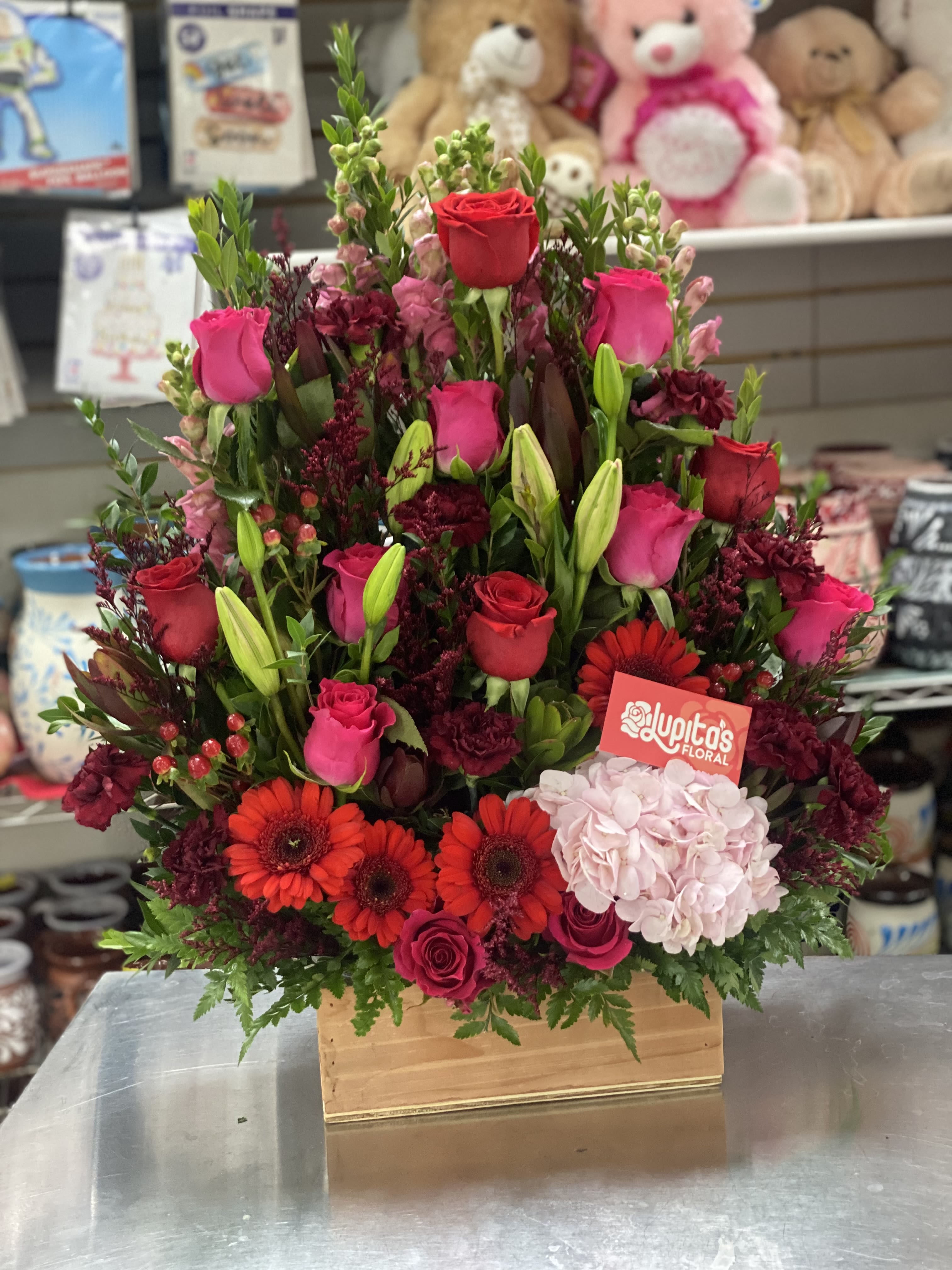 Mixed bouquet of red and pink roses with gerbera daisies in a wooden box