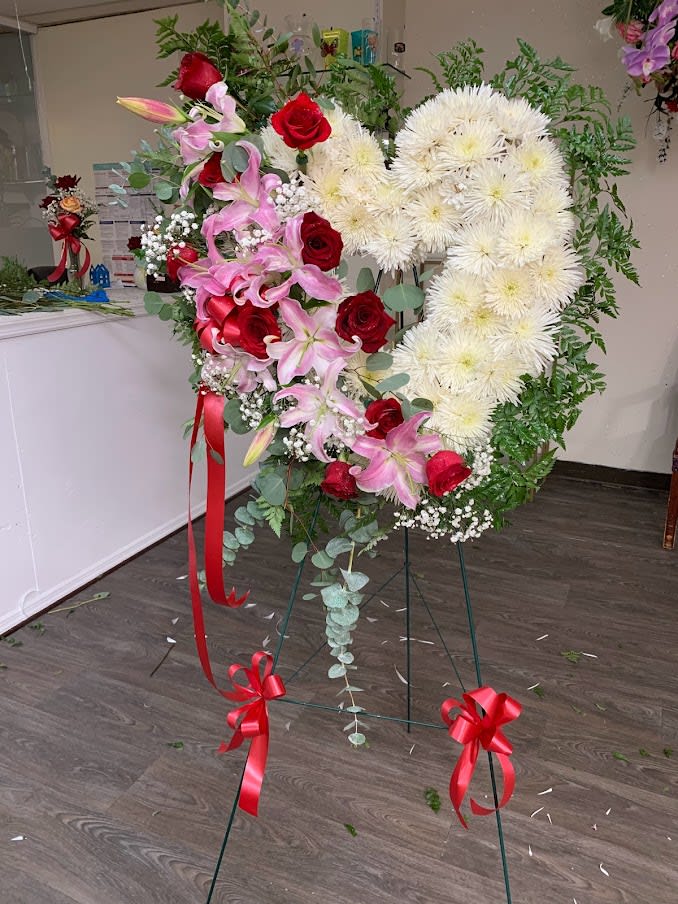 Heart-shaped floral standing spray with red roses, pink lilies, and white chrysanthemums