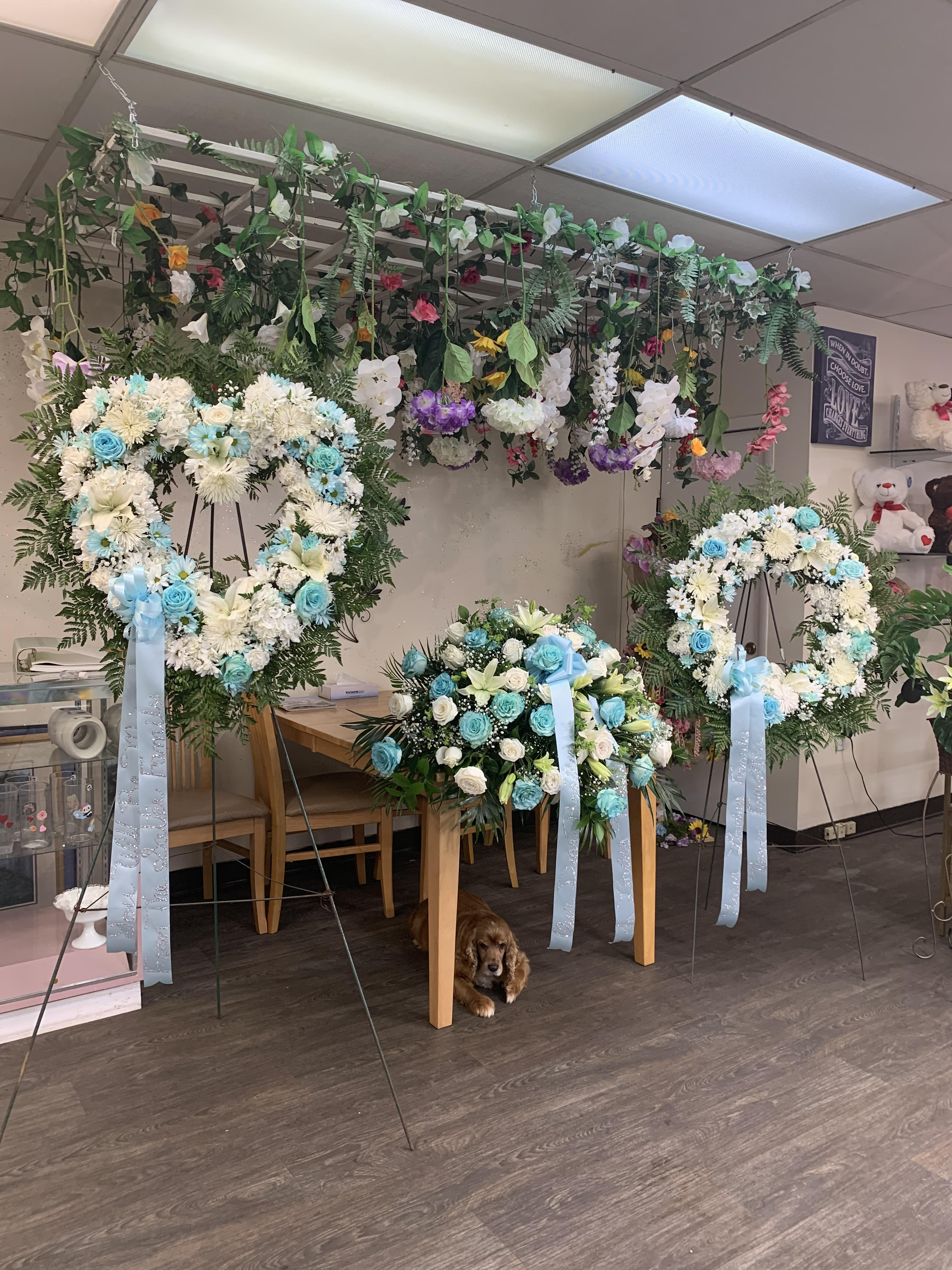 Heart-shaped floral wreaths on stands with blue and white flowers
