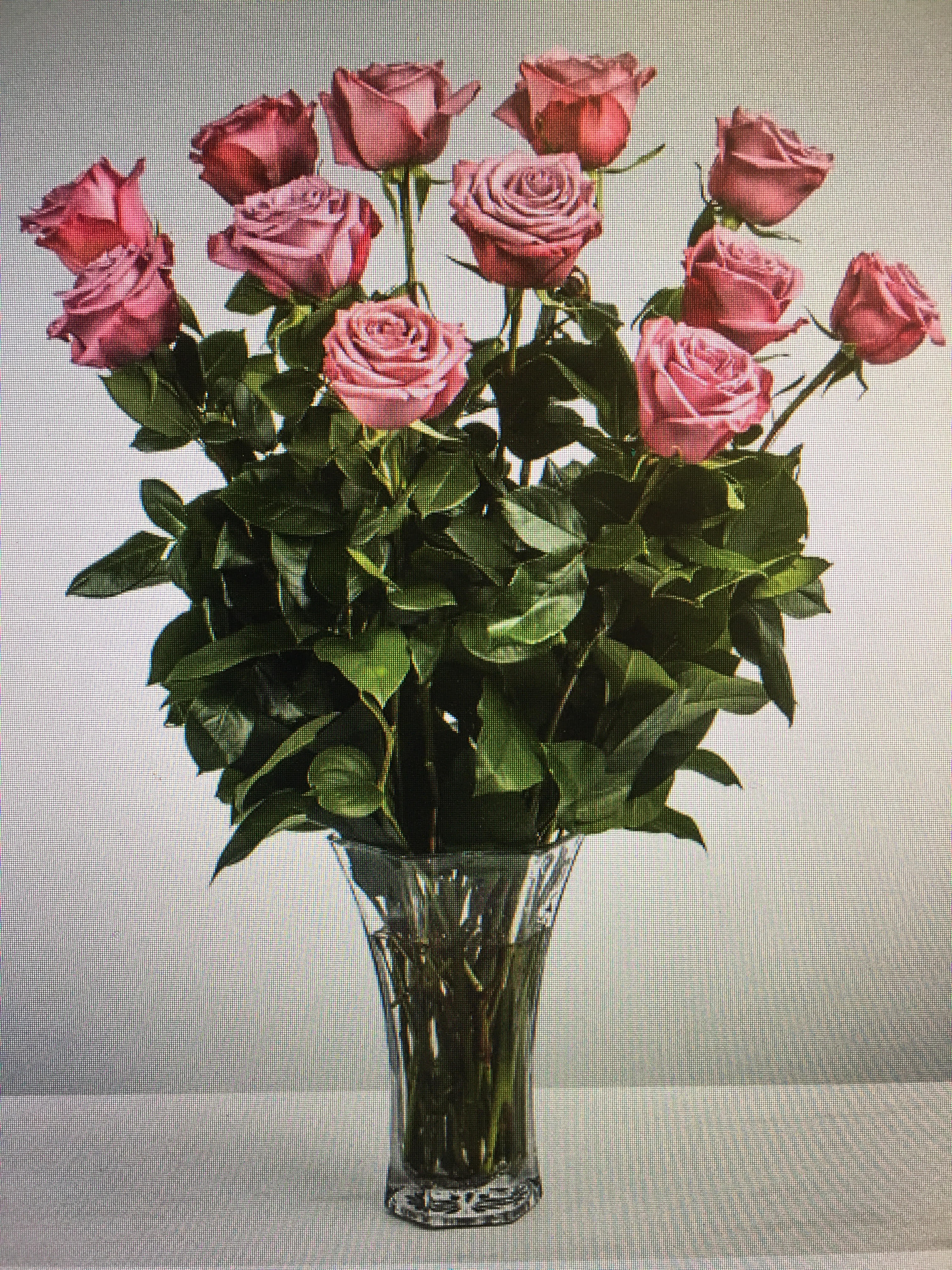 Pink roses arranged in a clear glass vase