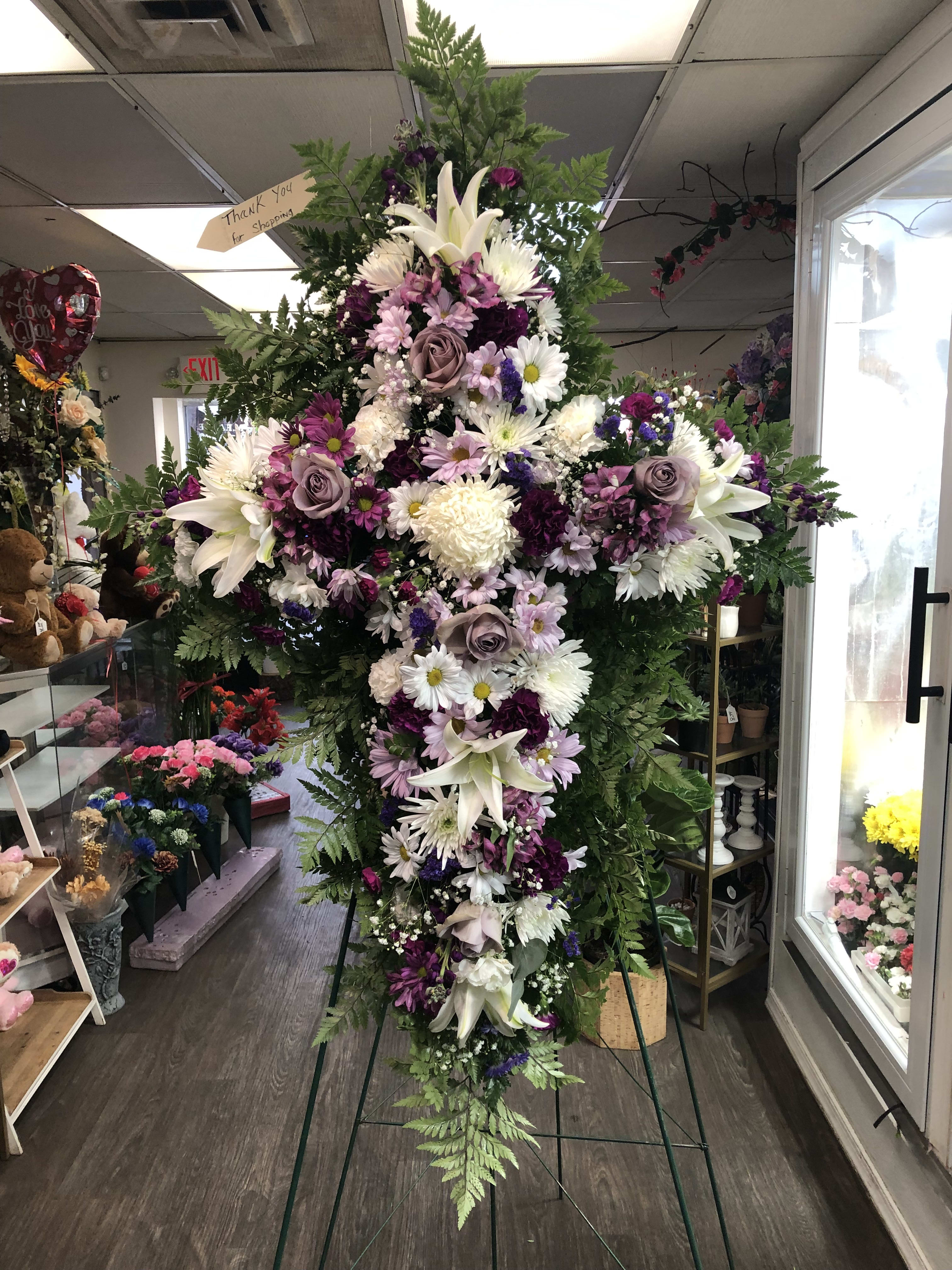 Tall standing floral spray with white lilies and purple flowers