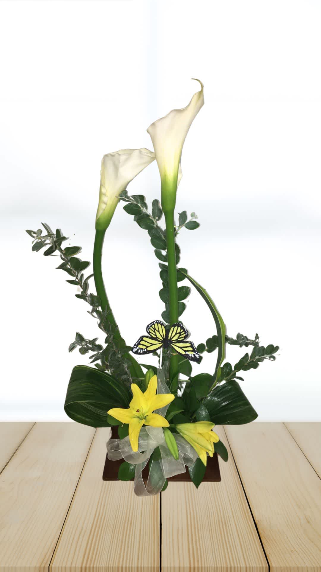 Tall floral arrangement with white calla lilies and yellow lilies