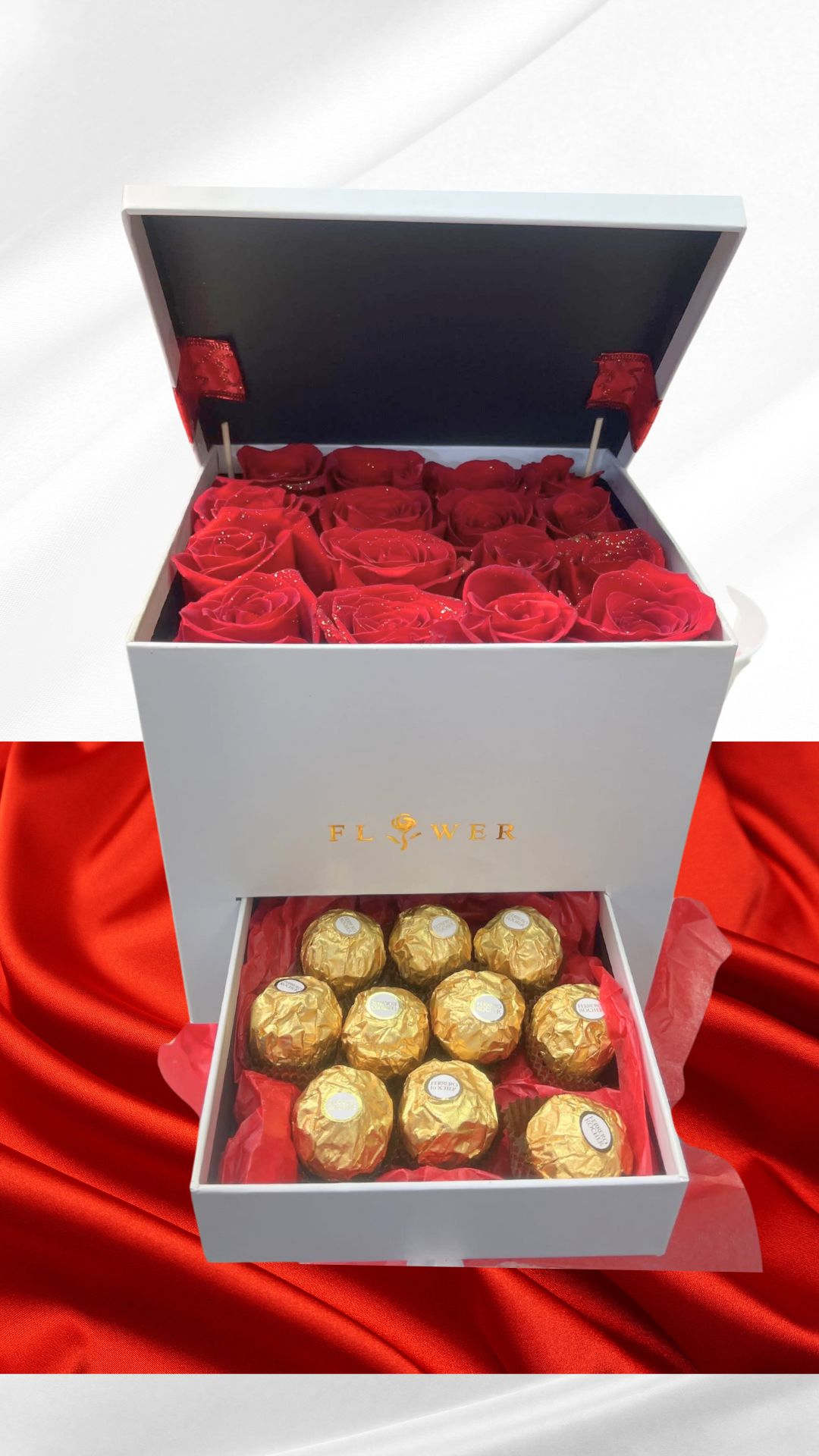 Open gift box with red roses and gold-wrapped chocolates
