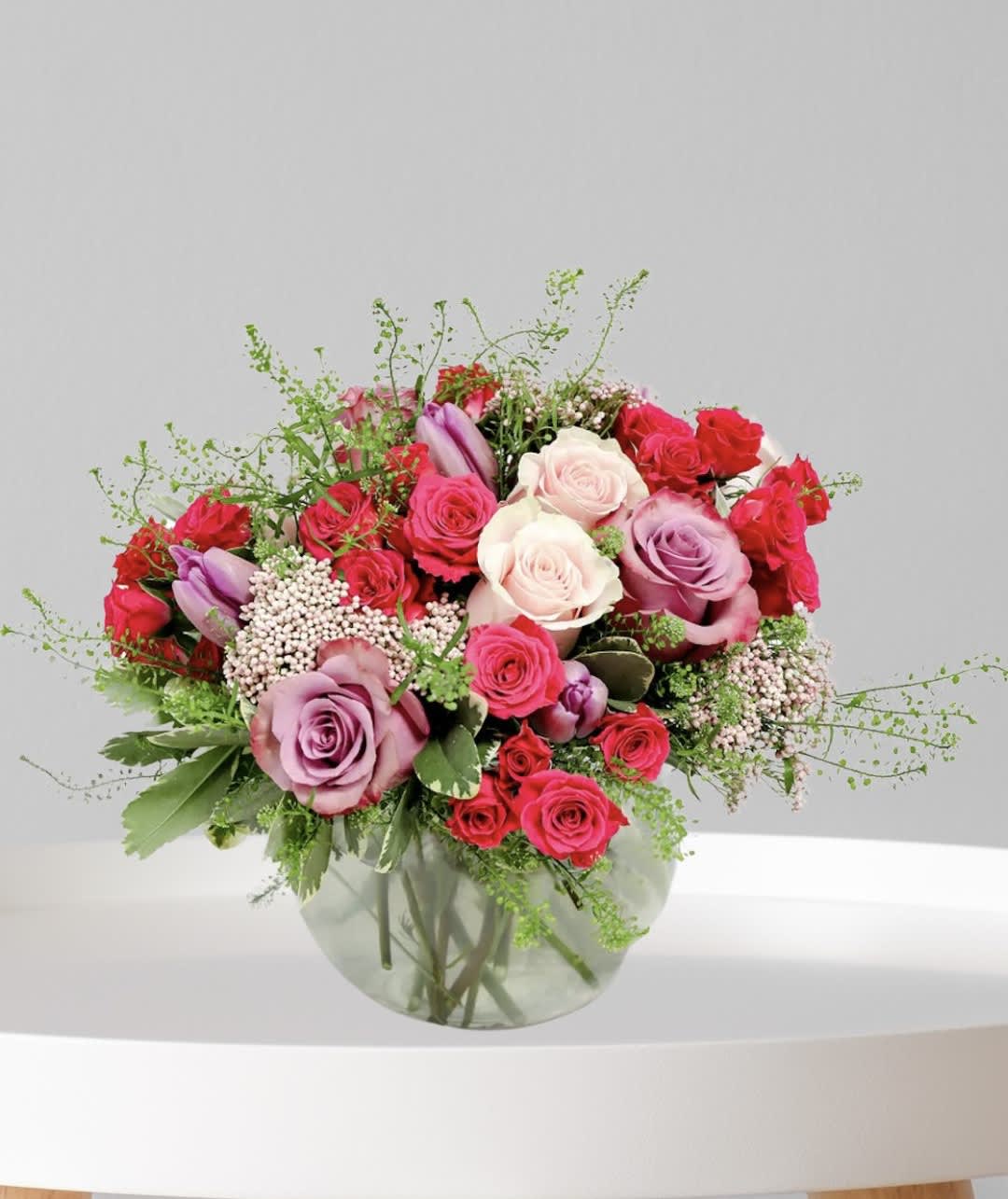 Bouquet of pink, red, and white roses in a glass vase
