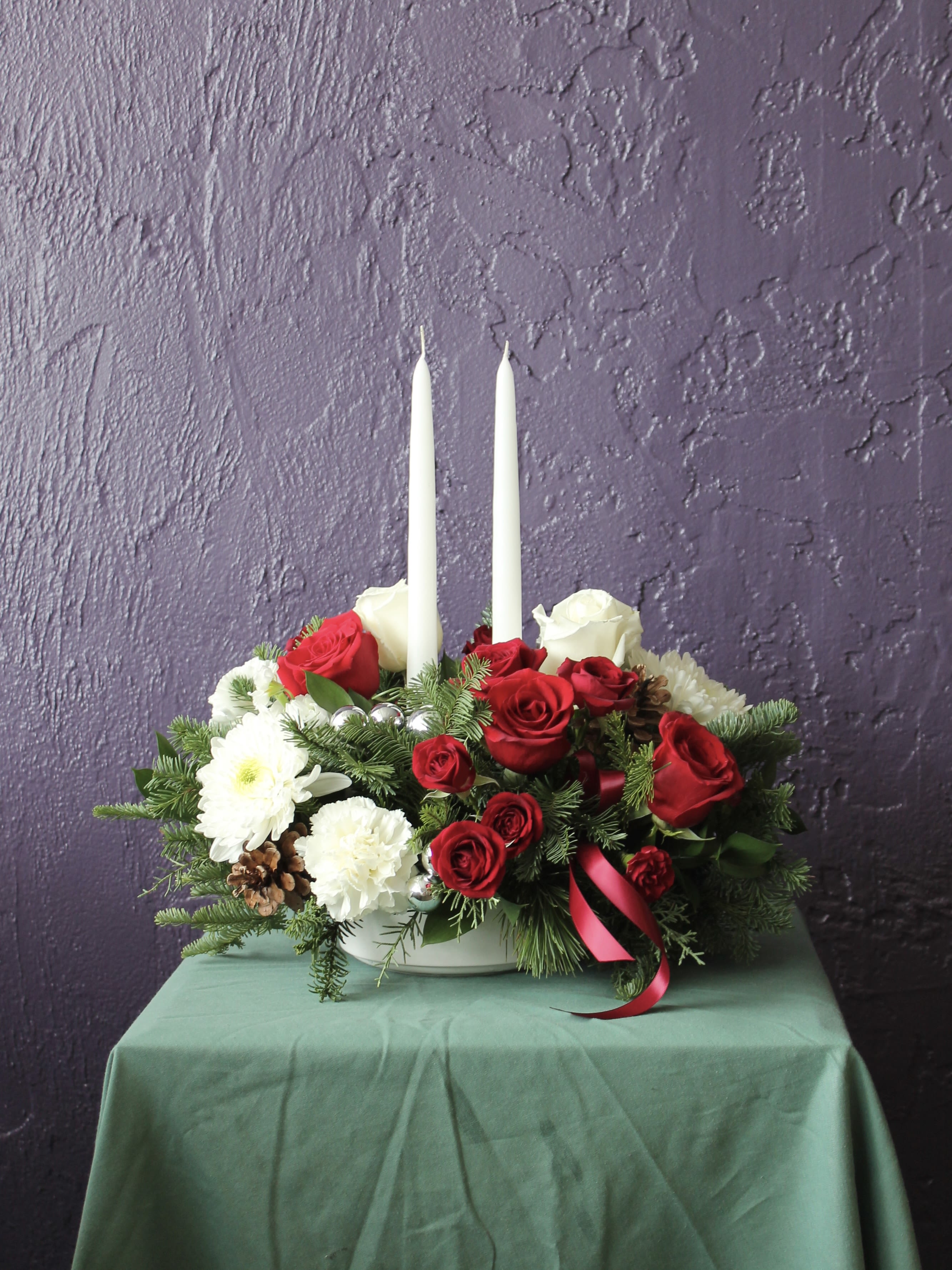 Red and white rose centerpiece with two white taper candles