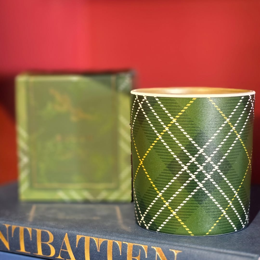 Green plaid paper cup on a book with a matching box behind it