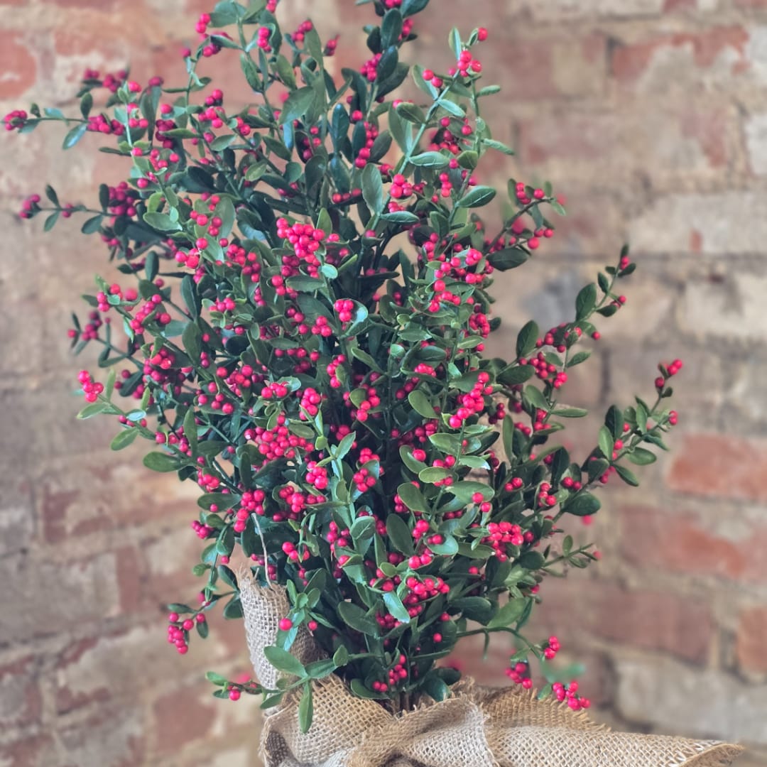 Berry-covered greenery arrangement in a burlap wrap