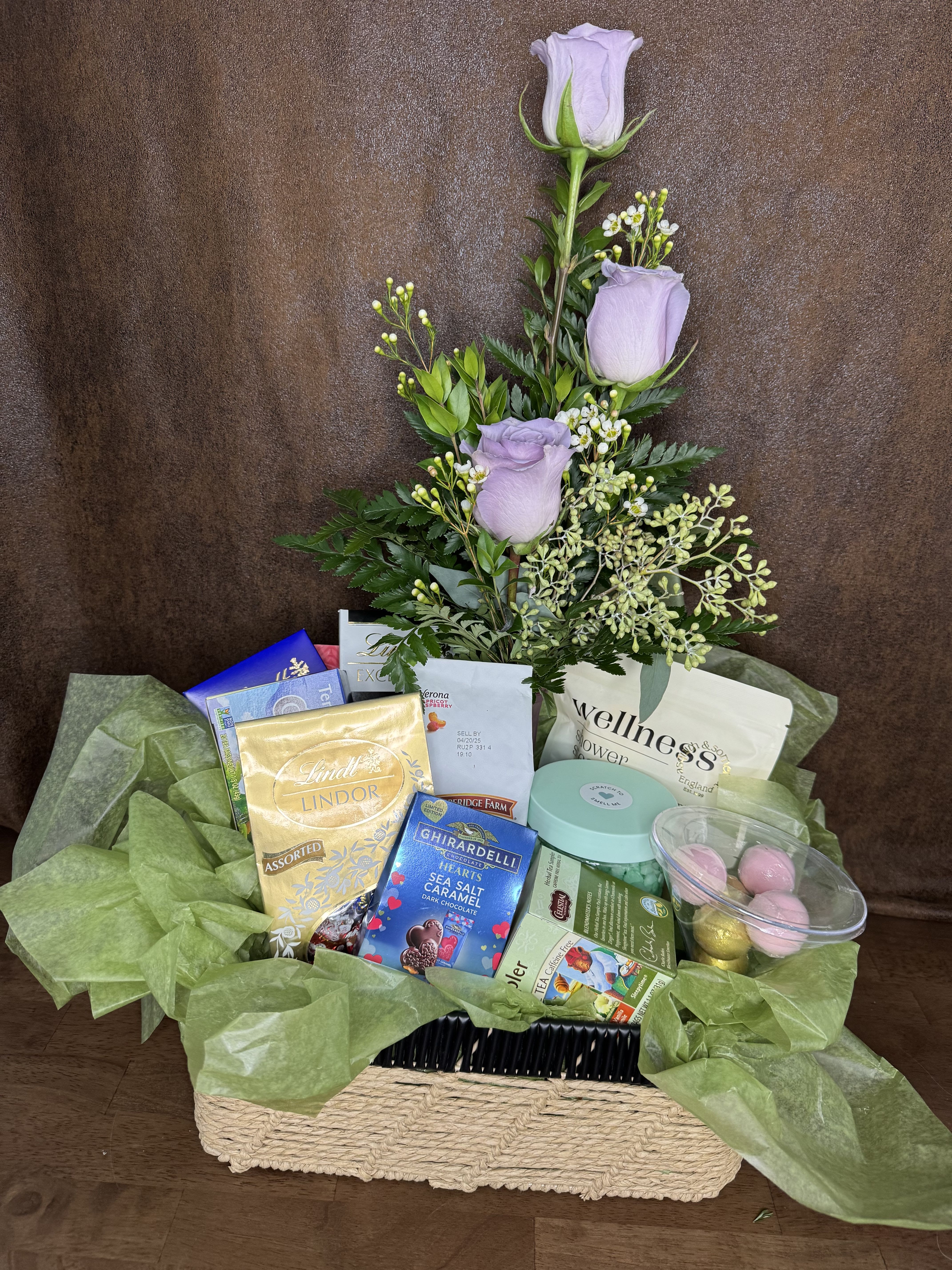Lavender roses in a gift basket with chocolates and tea
