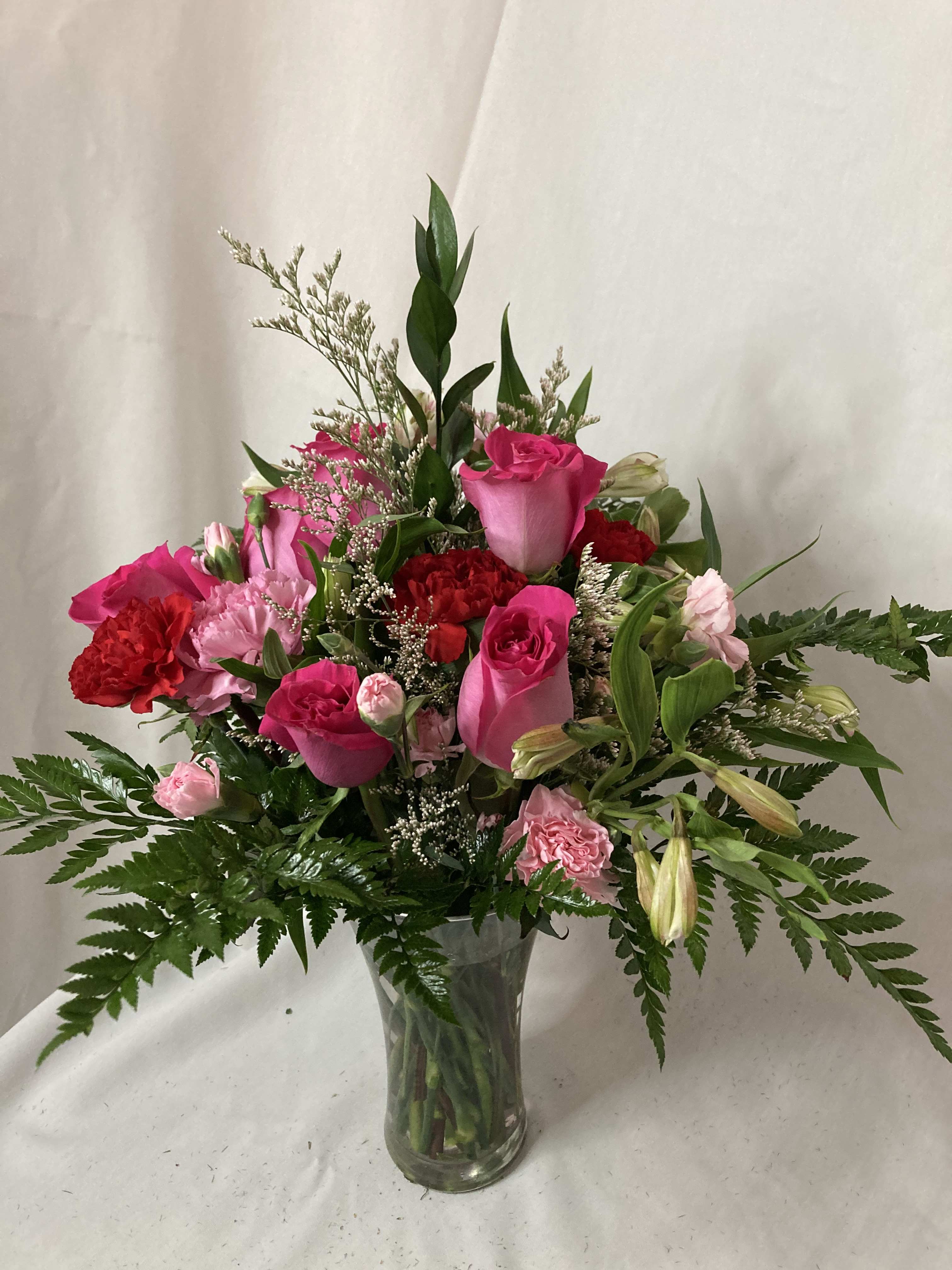 Pink and red flower arrangement in a clear glass vase