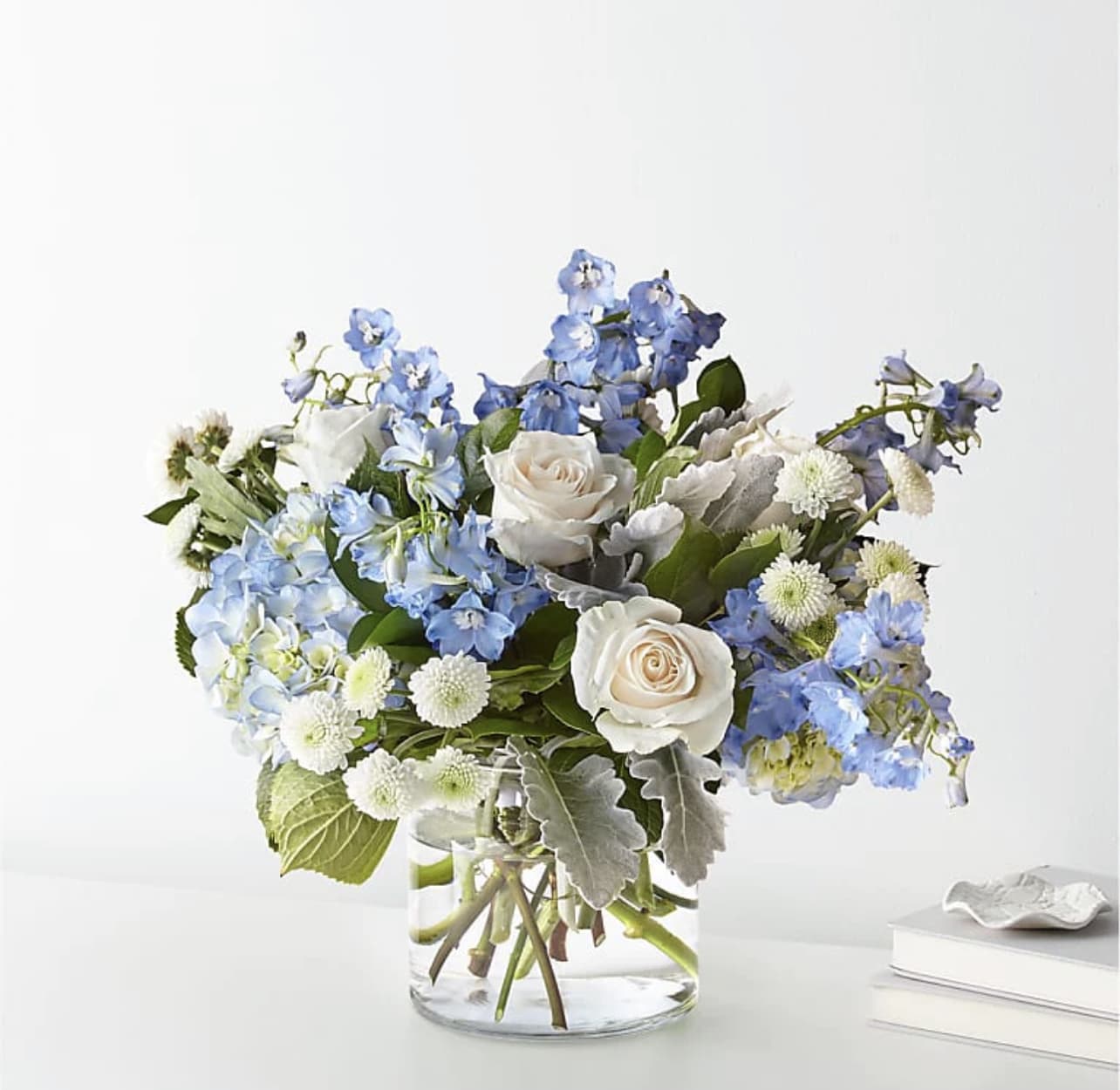 Blue and white flower arrangement in a clear glass vase