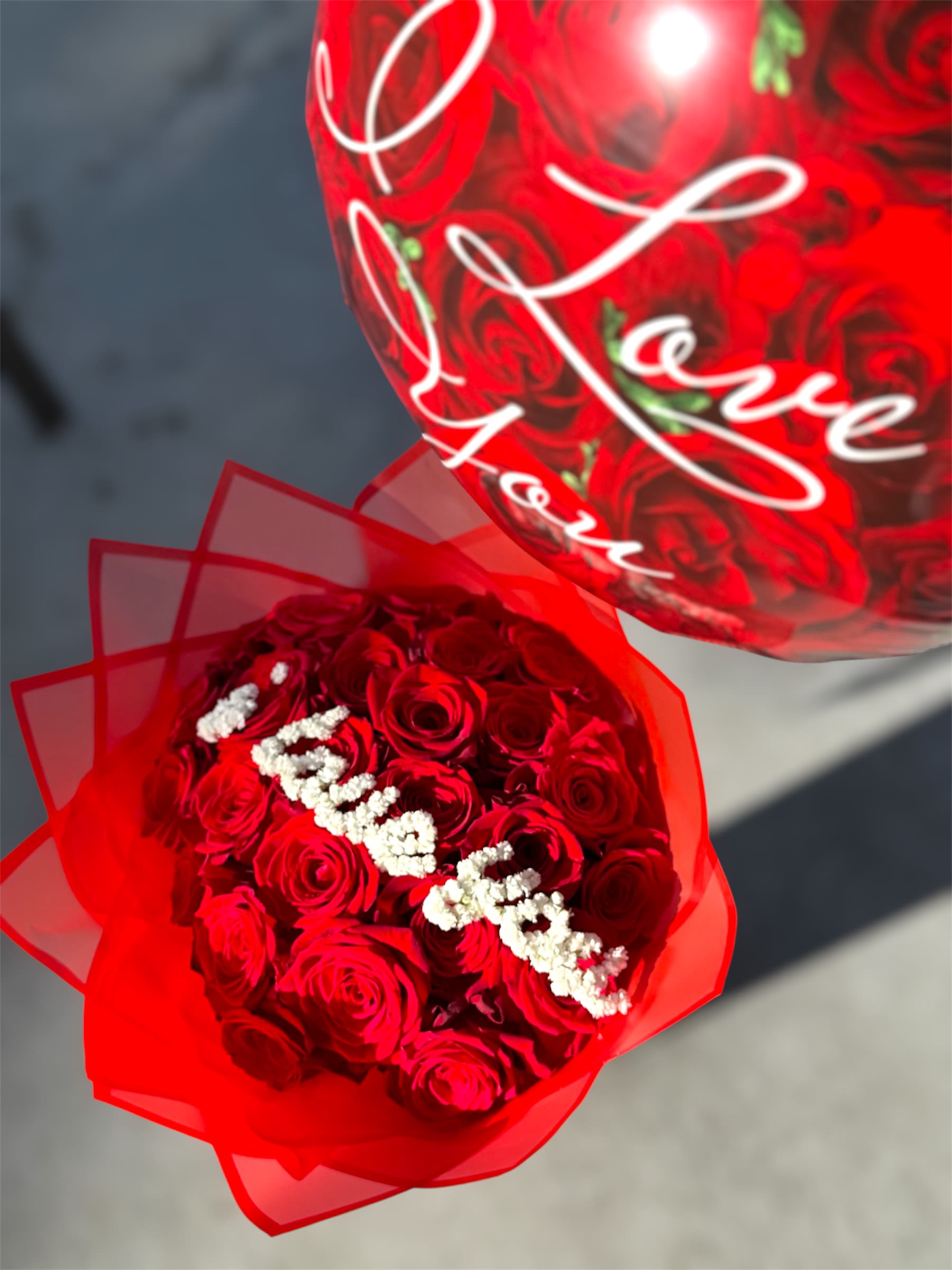 Red rose bouquet with white baby's breath and a heart balloon