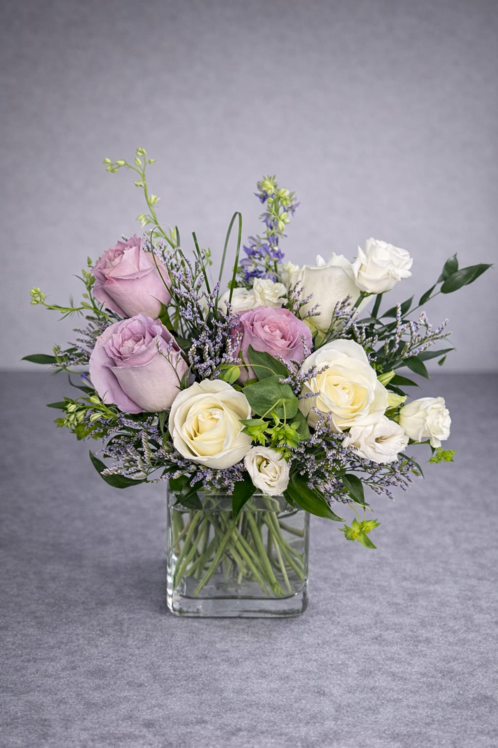 Bouquet of lavender and white roses in a clear glass vase