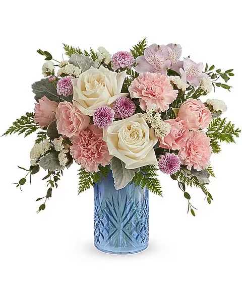 Blue Belle Bouquet - The Blue Belle Bouquet is a sweet Mother's Day flower arrangement of soft pink, white, and lavender blooms, beautifully presented in the Blue Belle Vase keepsake-perfect for celebrating Mom with fresh spring charm. The Blue Belle Bouquet features white roses, pink spray roses, lavender alstroemeria, pink carnations, lavender button spray chrysanthemums, and white sinuata statice, accented with dusty miller, parvifolia eucalyptus, and Cleopatra leatherleaf fern, in the Blue Belle Vase.  