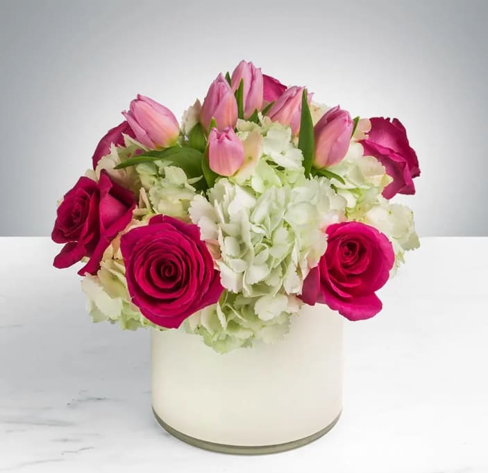 Fun &amp; Flirty by BloomNation™ - This cheerful bouquet brings lighthearted fun to any occasion. Fun &amp; Flirty by BloomNation™ is the perfect gift to wish someone a happy birthday or to say thank you.   Arrangement Details: Includes hot pink roses, pink tulips, and white hydrangea. APPROXIMATE DIMENSIONS: 12" H X 11" W 