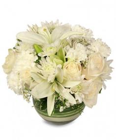 White floral arrangement in a green glass bowl vase