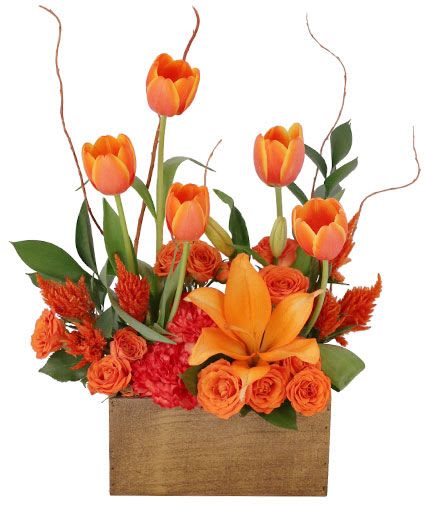 Orange tulips and roses arranged in a wooden box
