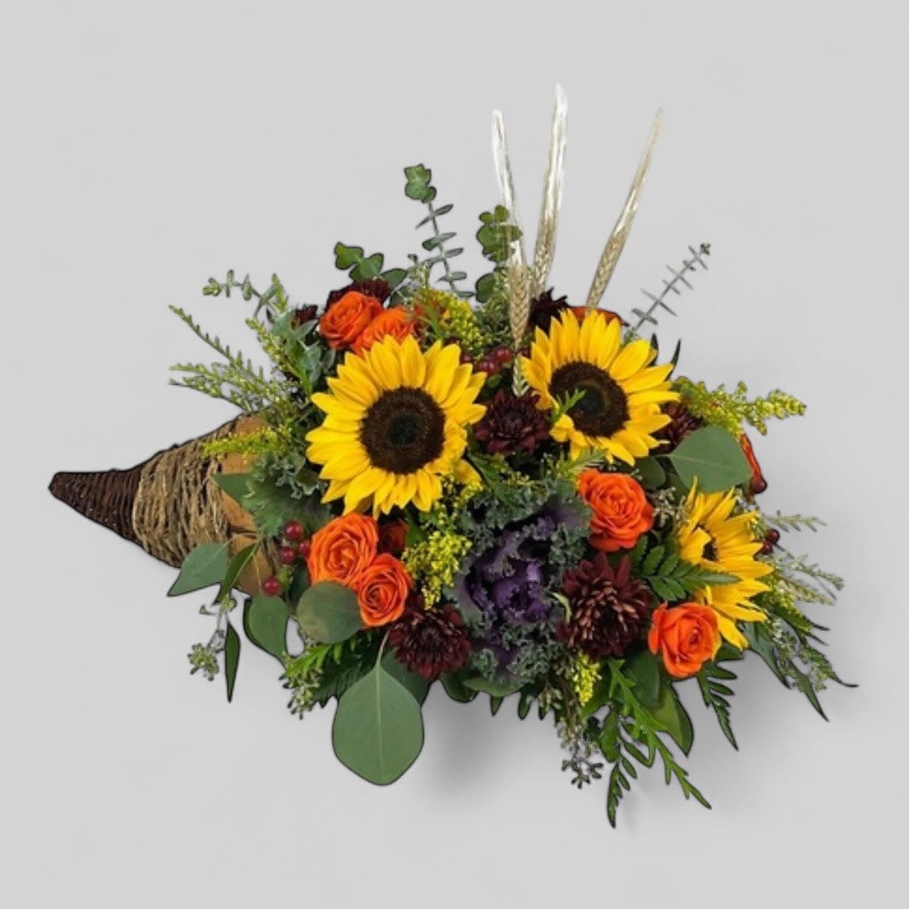 Bouquet with sunflowers and orange roses wrapped in burlap