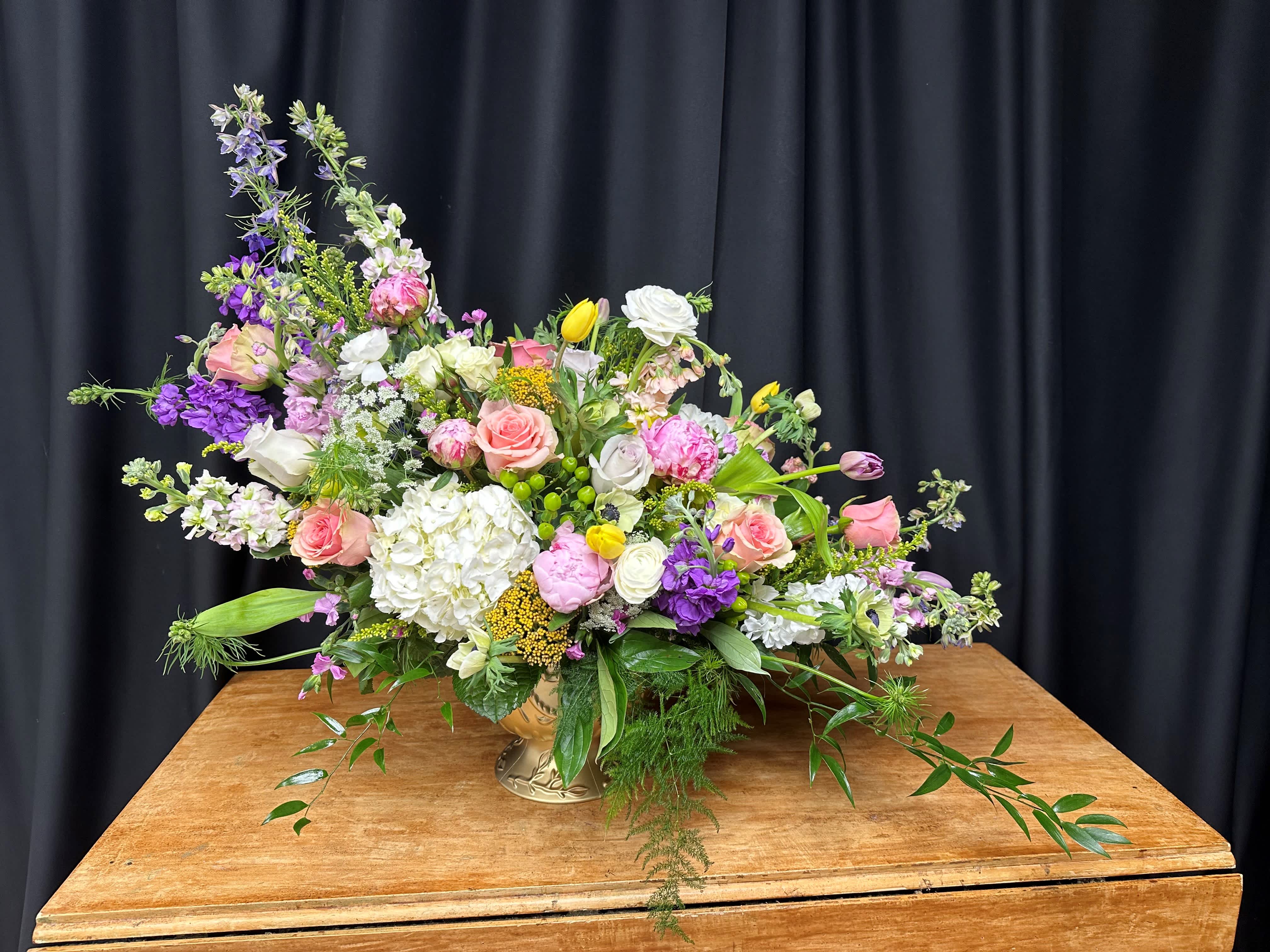 Large mixed bouquet in a gold vase with pink, white, and purple flowers