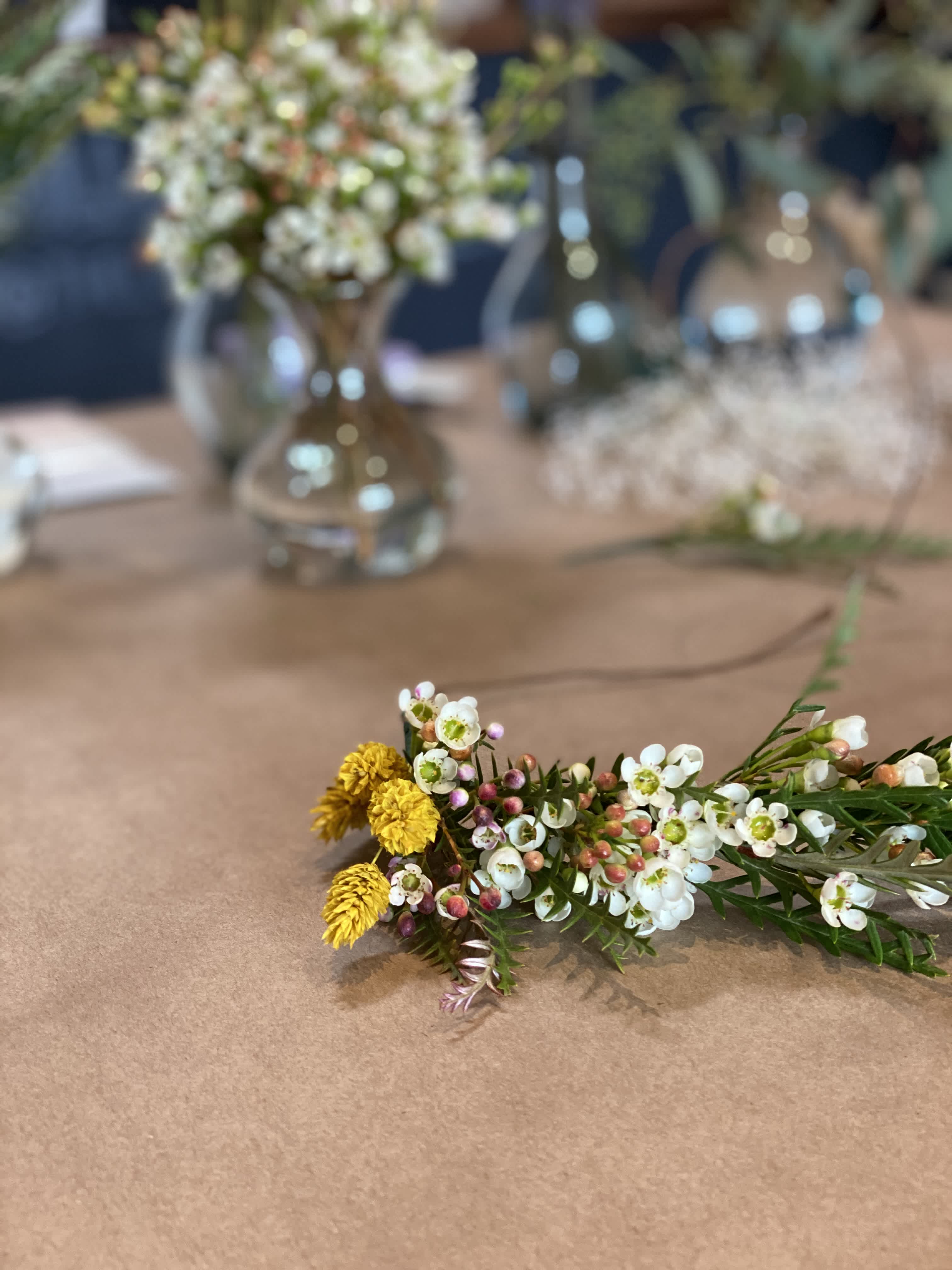 Small floral sprig with white and yellow blossoms on a table