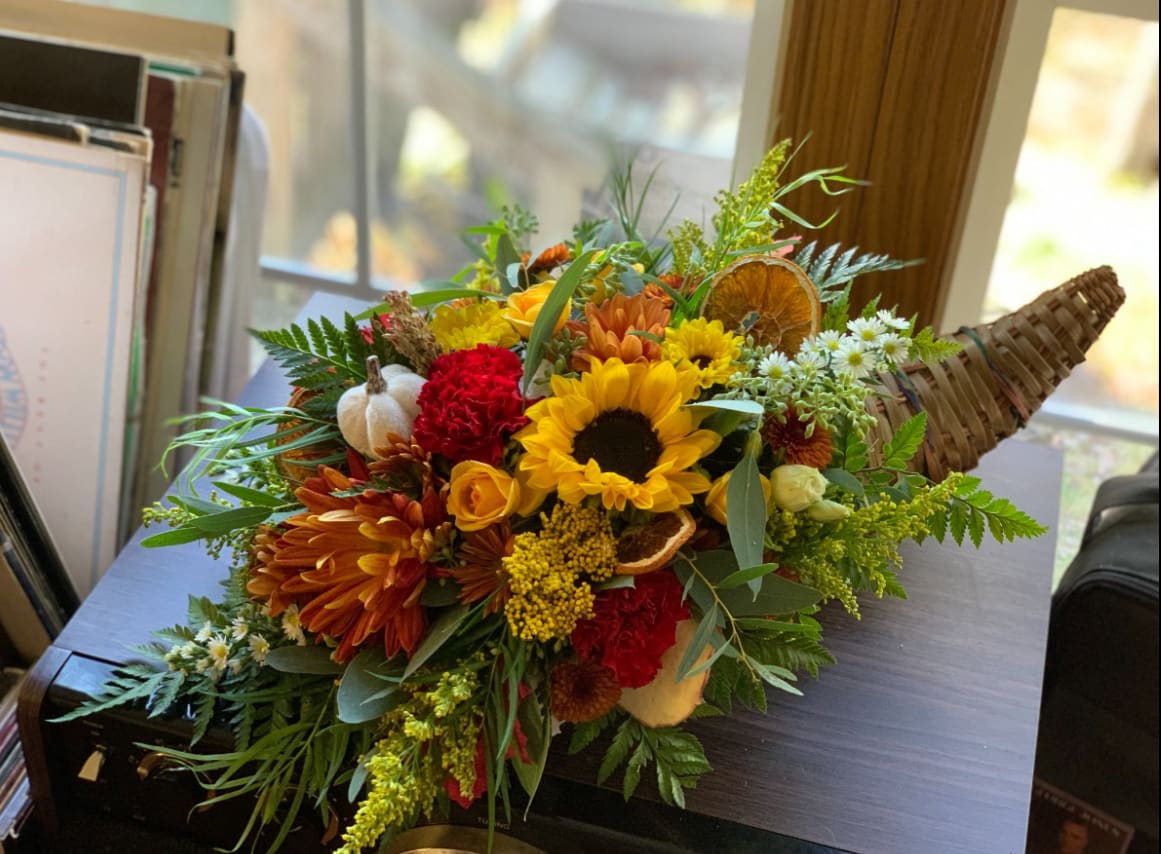 Traditional Thanksgiving Cornucopia  - Cornucopias are a beautiful way to add some Decor to your Thanksgiving Dinner. Filled with fall focals and accent flowers, this arrangement is sure to make you feel the holidays just a bit more. 