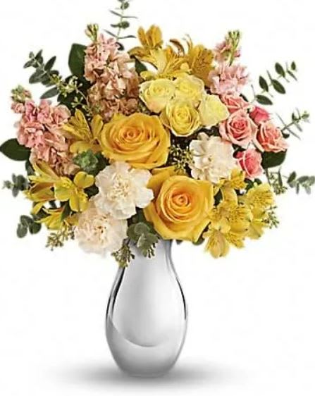 Soft Reflections Bouquet - Soft, sunshiny blooms and a sparkling silver vase combine to striking effect in this magnificent bouquet. Its yellow and peach roses and keepsake vase are sure to make them smile, no matter the occasion! This soft mix of yellow roses, light yellow spray roses, peach spray roses, yellow alstroemeria, crÃ¨me carnations and peach stock is accented with spiral and seeded eucalyptus. Delivered in a Silver Reflections vase. 