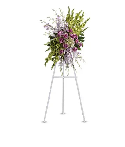 Tall floral spray on a white easel with purple flowers and green accents