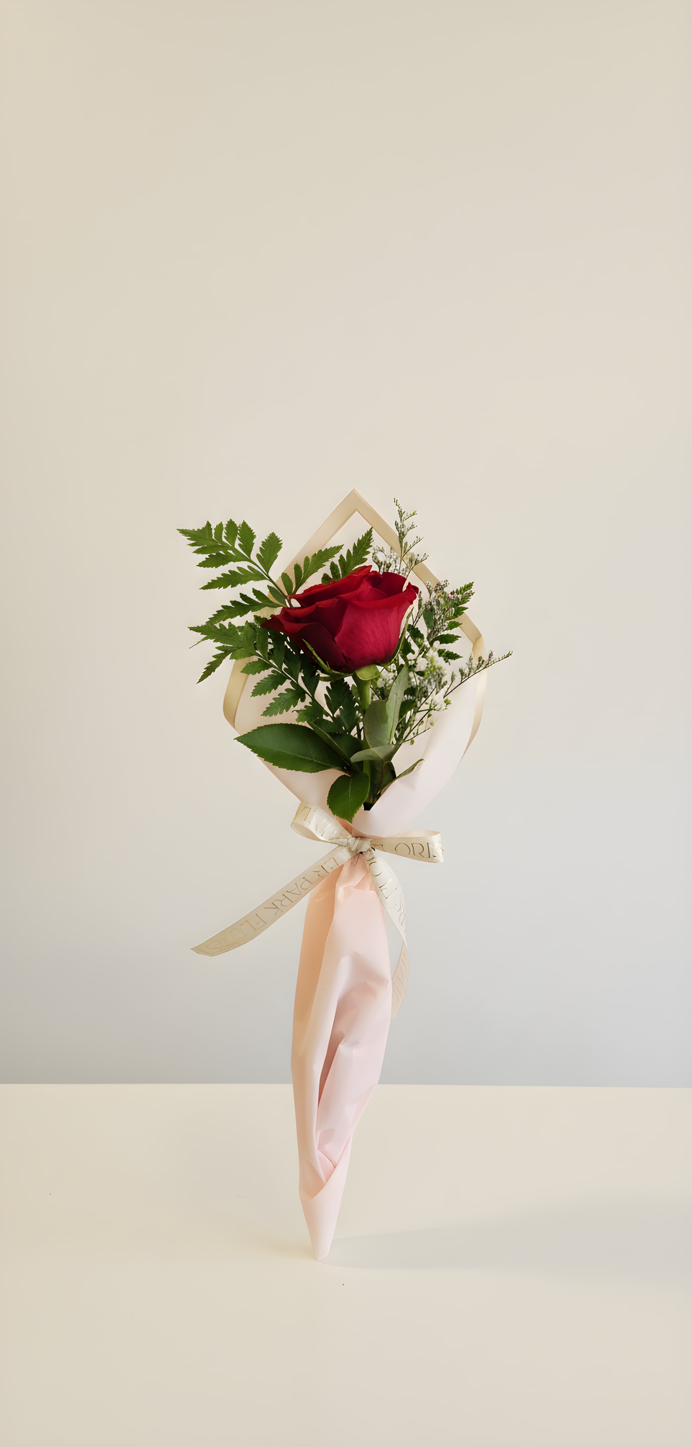 Single Rose - Wrapped - One wrapped rose with complimentary greens and filler.