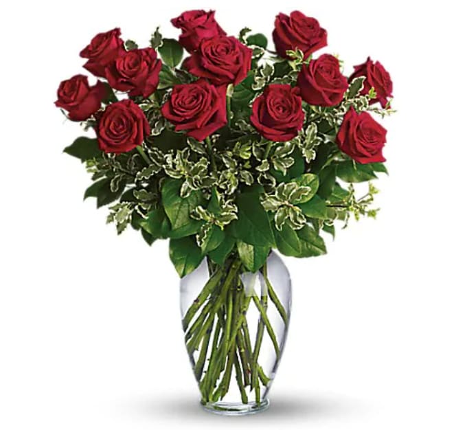 Red roses arranged in a clear glass vase