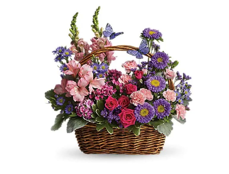 Basket arrangement of pink and purple flowers with butterfly accents