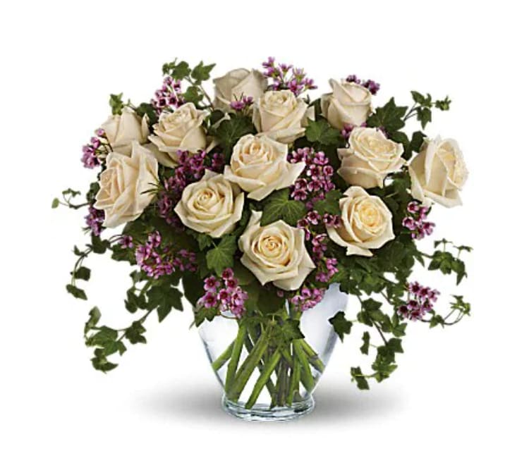 Victorian Romance - Romance blossoms beautifully within this elegant bouquet. The serenity and innocence of cream-colored roses is in delightful juxtaposition with lavender roses and waxflower accented with fresh ivy greens. It's as romantic as a stroll through the English countryside. Fifteen crème roses and nine lavender roses, lavender waxflower and ivy are perfectly arranged in a serenity glass vase.   Orientation : All-Around  All prices in USD ($) 