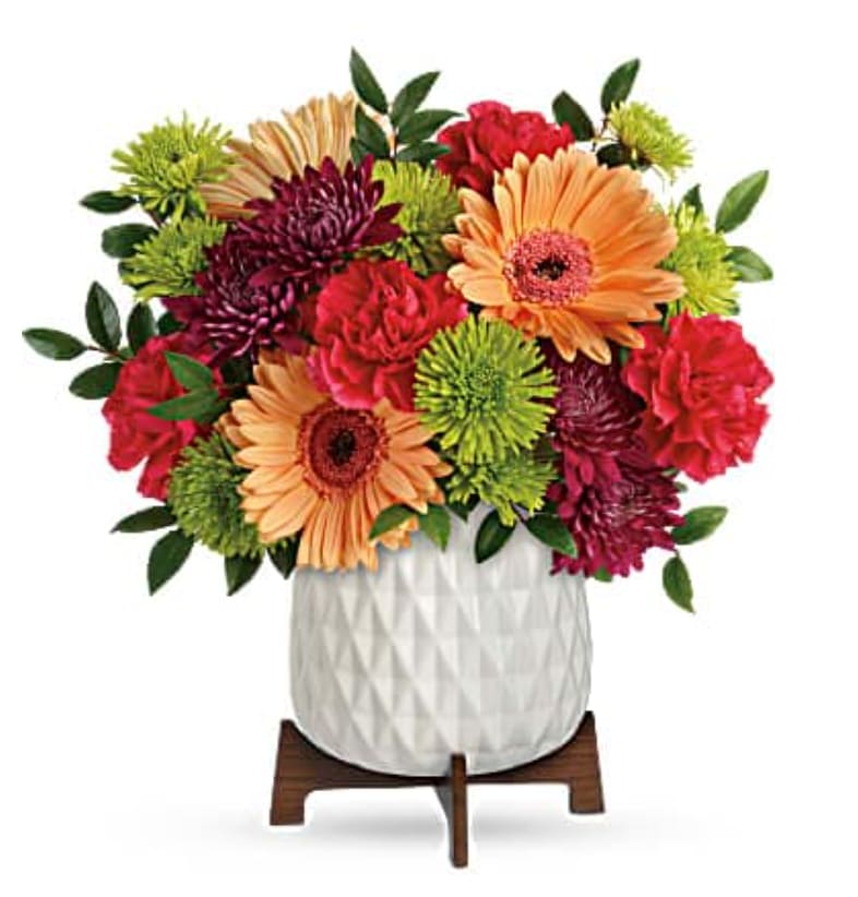 Mid Mod Bright Bouquet - Two gorgeous gifts in one! Celebrate any occasion with this bouquet of bright blooms, stylishly presented in a mod mid-century ceramic planter keepsake! This bright bouquet features hot pink roses, peach gerberas, hot pink carnations, green cushion spray chrysanthemums, purple cushion spray chrysanthemums, and huckleberry. Delivered in a Mid Mod Geometric Planter.   Orientation : All-Around  All prices in USD ($)  Standard  TEV58-7A  Deluxe  TEV58-7B  Premium  TEV58-7C