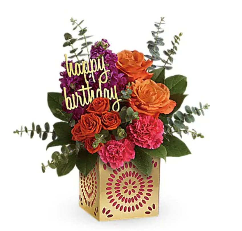 Birthday Sparkle Bouquet - Add some extra special sparkle to their birthday with this grand gift! Hand-delivered in a shimmering golden cube with intricate cutouts, this colorful bouquet will make their birthday week wonderful. Later, they can remove the pretty magenta liner and golden "happy birthday" pick and enjoy the cube as a pretty candleholder! This colorful mix features orange roses, orange spray roses, fuchsia stock, pink carnations, spiral eucalyptus and lemon leaf. Delivered in a Celebrate in Style cube.   