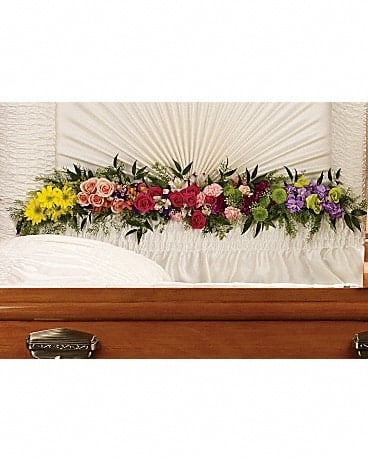 Glorious Memories Garland - Create a beautiful resting place with this magnificent garland of roses and other floral favorites artistically placed at the base of the casket lid. The exquisite arrangement includes hot pink spray roses, peach spray roses, light pink alstroemeria, pink miniature carnations, yellow daisy spray chrysanthemums, purple button spray chrysanthemums, green button spray chyrsanthemums, orange snapdragon, lavender stock and purple sinuata statice, accented with assorted greenery. 